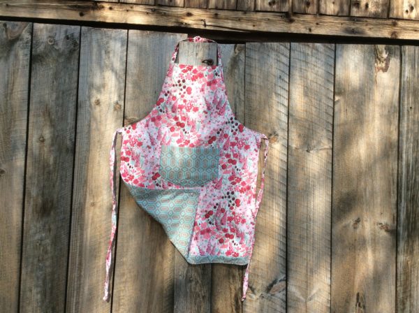 adult apron, red & pink flowers, geometric print pocket and reverse