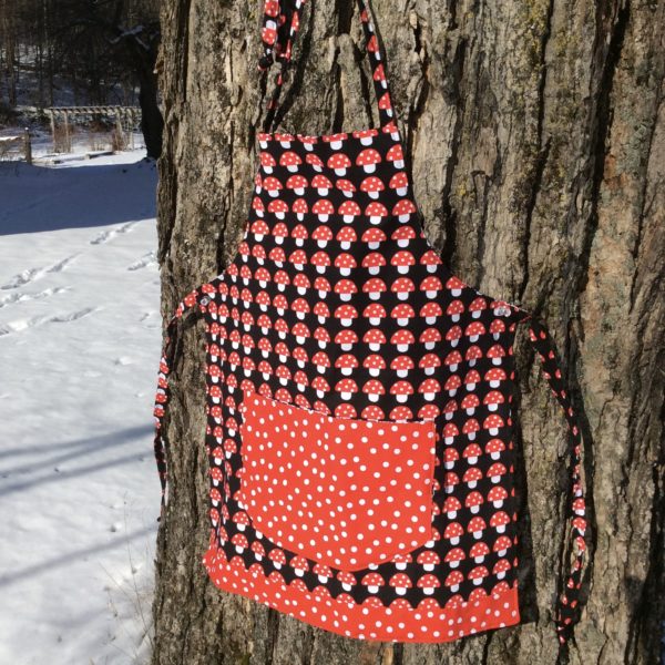 child apron with mushroom fabric and red polka dot fabric