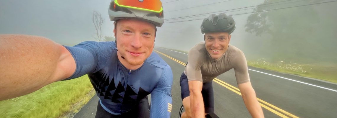 2 young men smiling and cycling