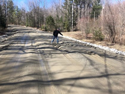 Man on dirt road with deep ruts