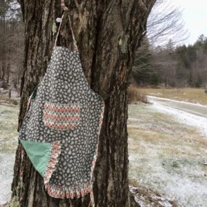 Grey patterned apron with peach white grey pocket and ruffle