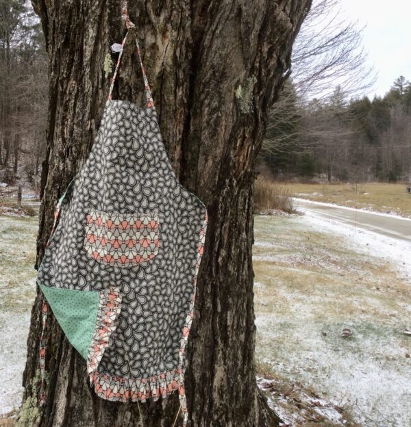 Grey patterned apron with peach white grey pocket and ruffle